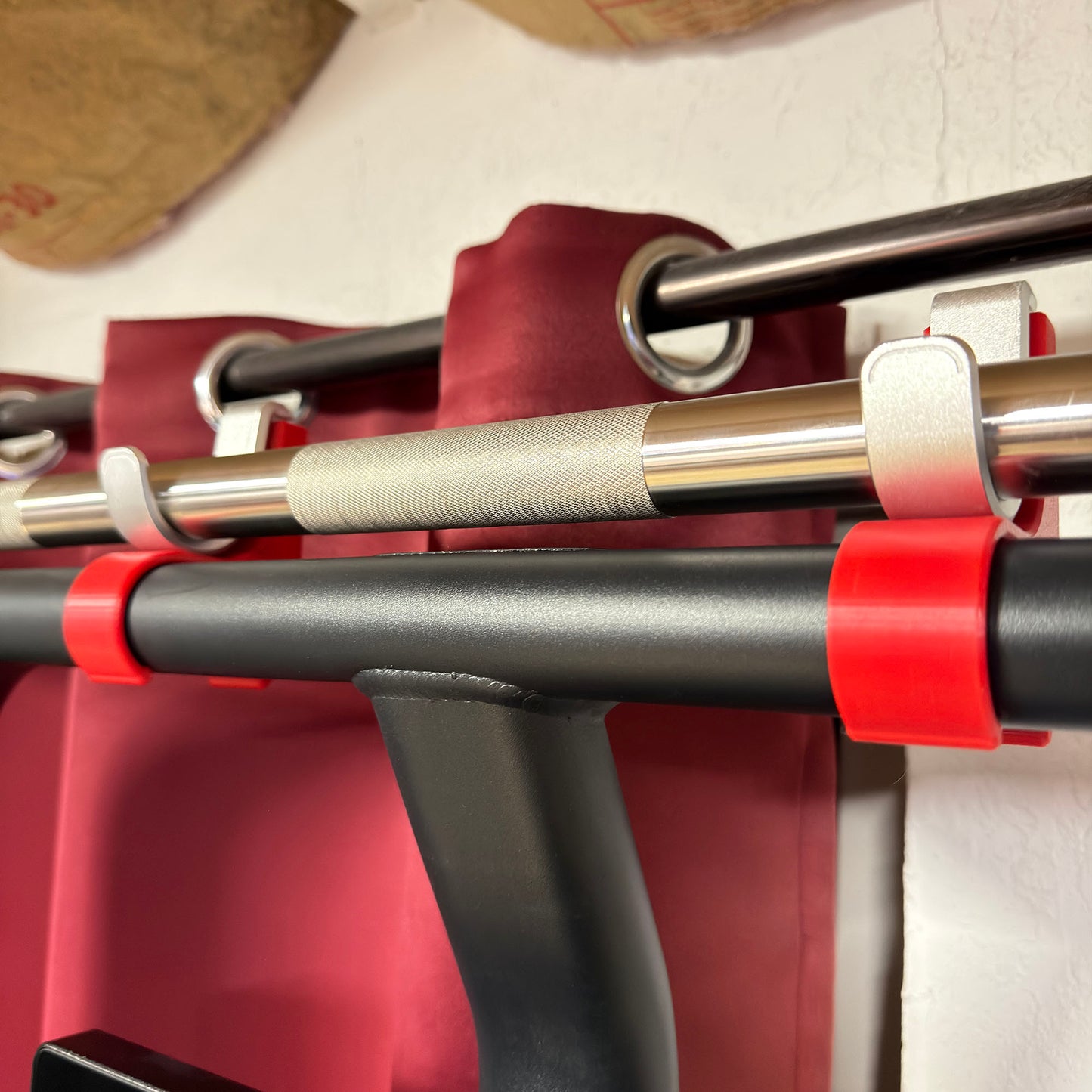 Close-up of a pull-up bar with red straps on a white background