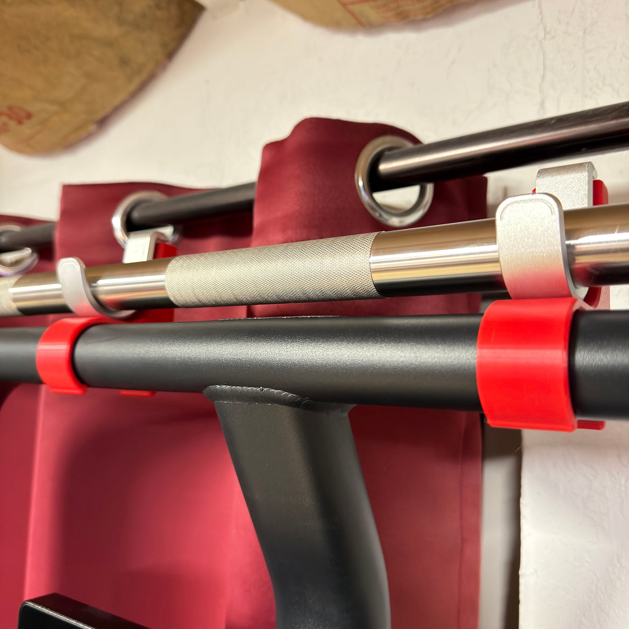 Close-up of a pull-up bar with red straps on a white background